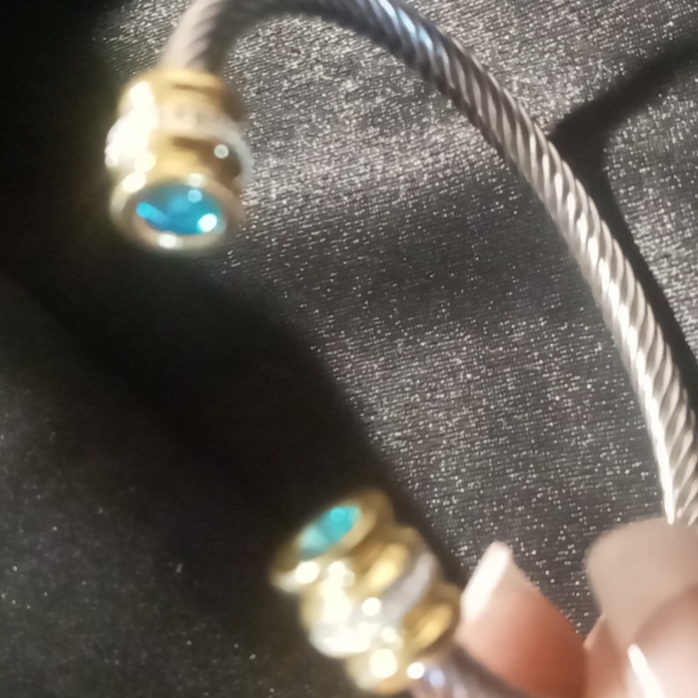 Twisted cable cuff bracelet with crystal cut blue ends silver and gold tone
